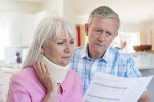 Woman with neck brace and a man holding a paper