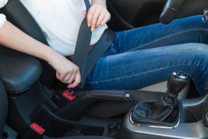 Woman fastens a seat belt. Safe driving concept